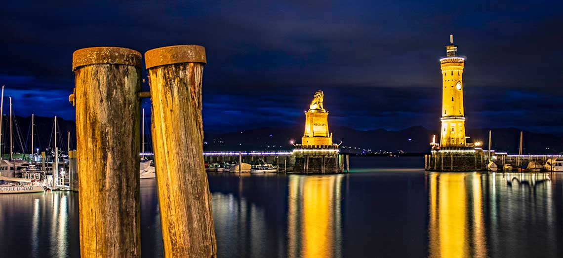 Lindauer Hafeneinfahrt mit Löwe und Leuchtturm bei Nacht